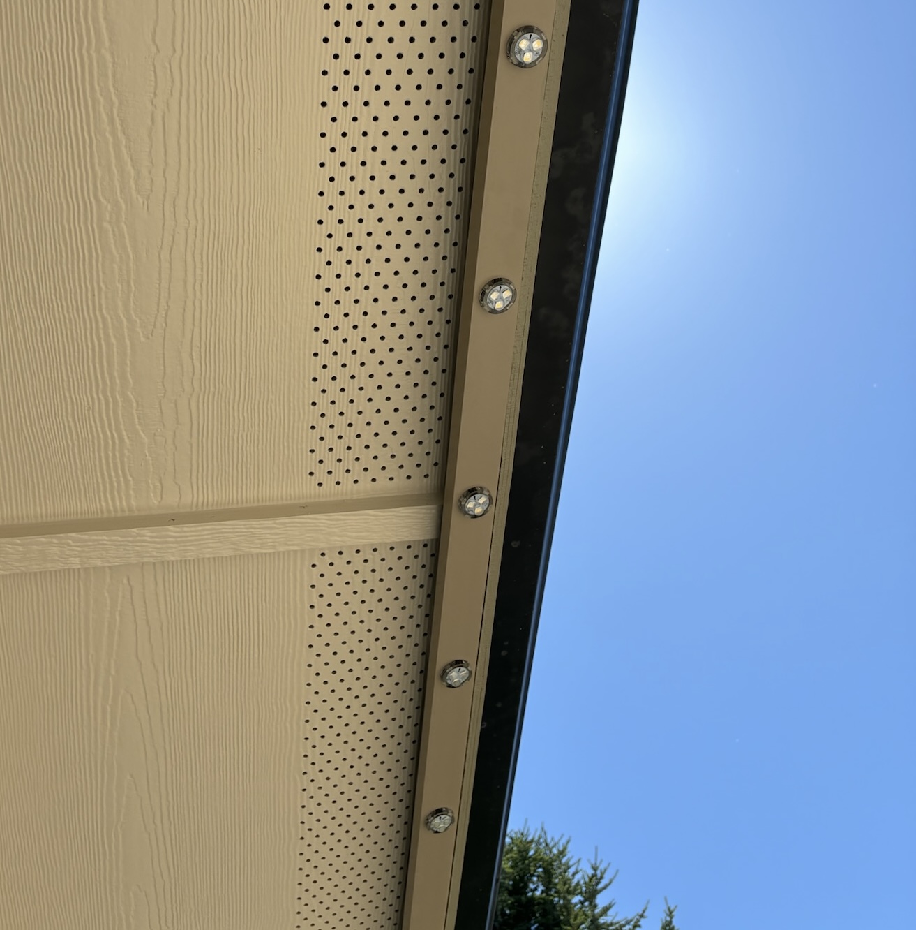 Underside view of the aluminum LED track color-matched to a beige fascia board