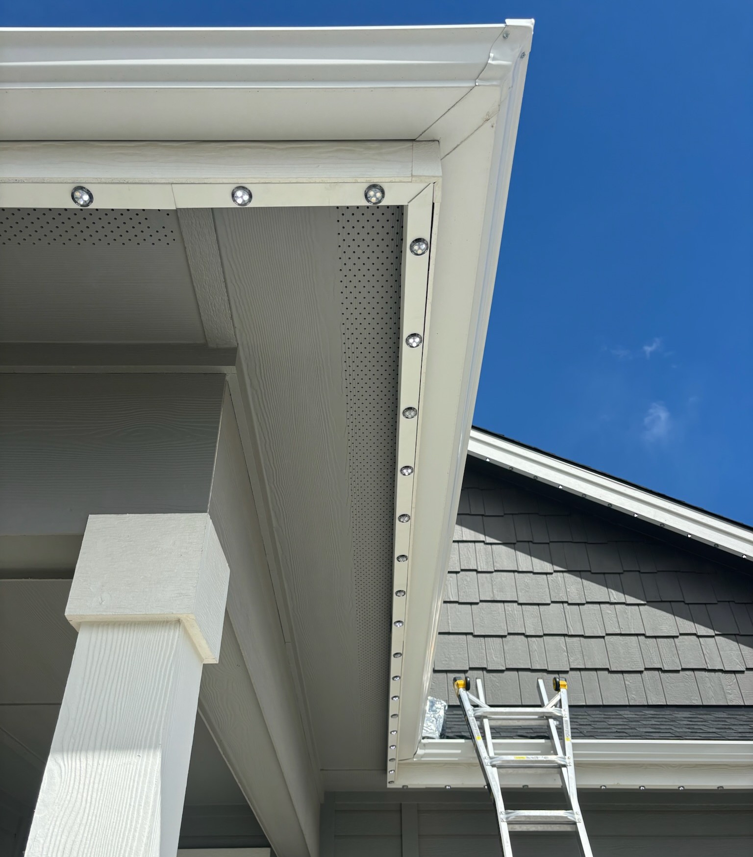 Underside view of the aluminum LED track installed behind a white fascia board