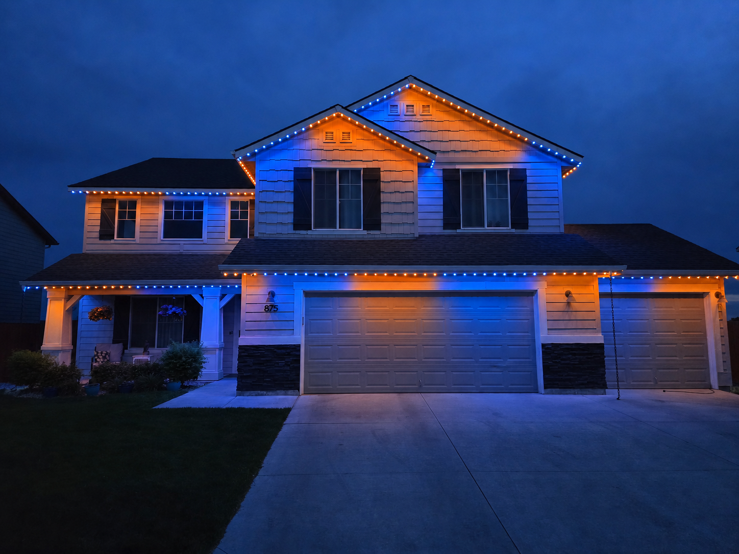Two-story home outlined in patriotic red, white and blue permanent LED lighting at night