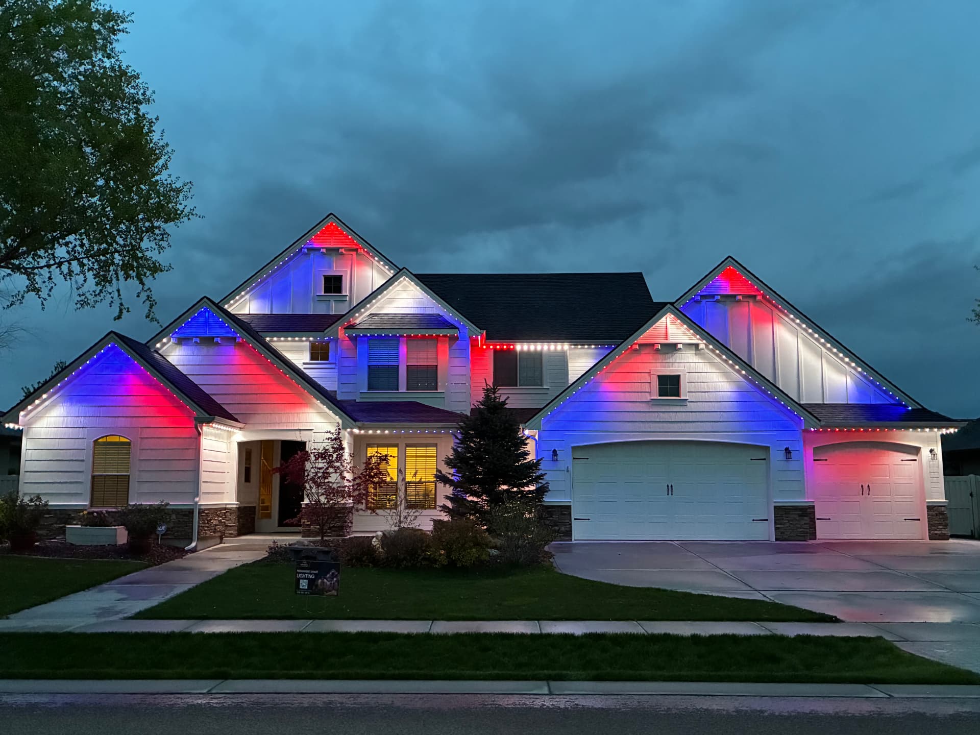 Two-story home showing red, white and blue lighting accents