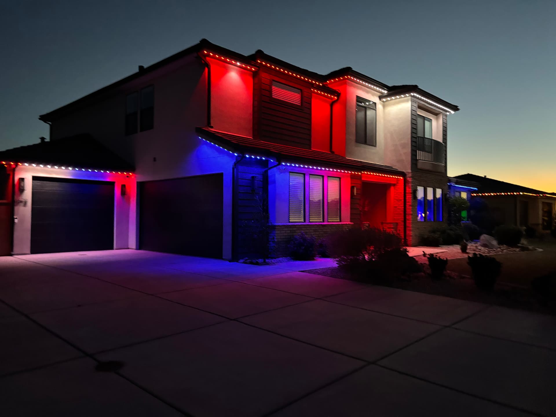 Two-story home lit in red, white and blue during a color test